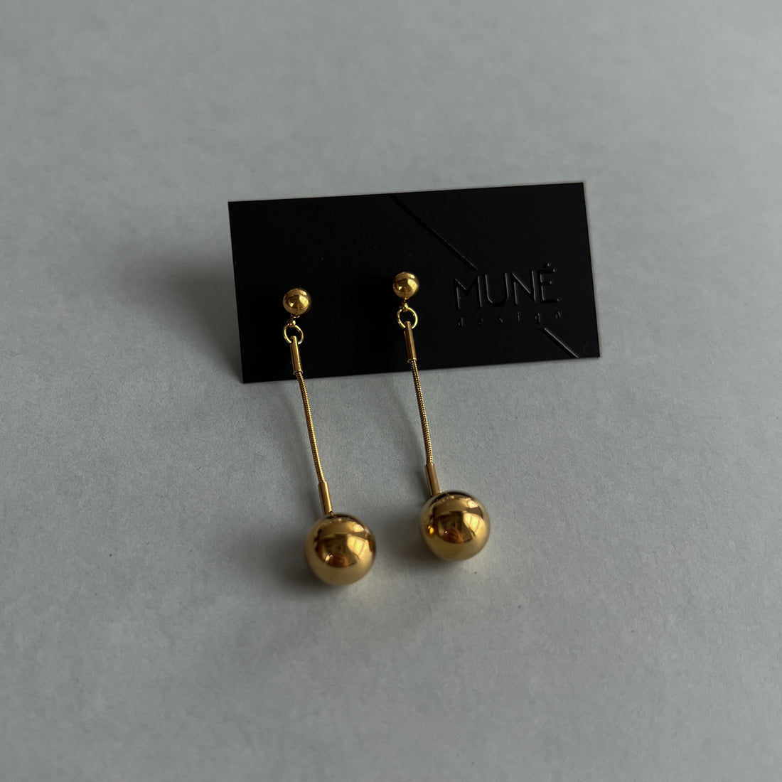 Kabantys aukso spalvos auskarai.