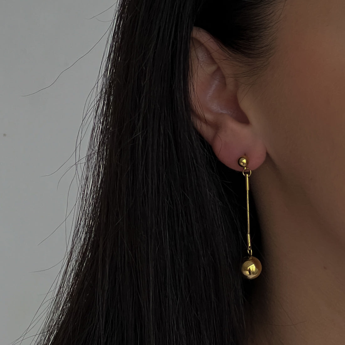 Kabantys aukso spalvos auskarai.